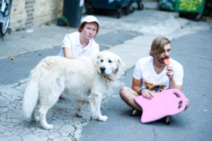 Zwei Personen in sitzender Position mit Hund.