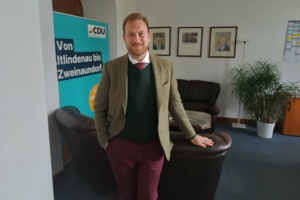Michael Weickert vor Fotos von Franz-Josef Strauß und Konrad Adenauer.